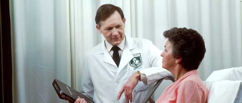 A doctor talking with a patient at the bedside